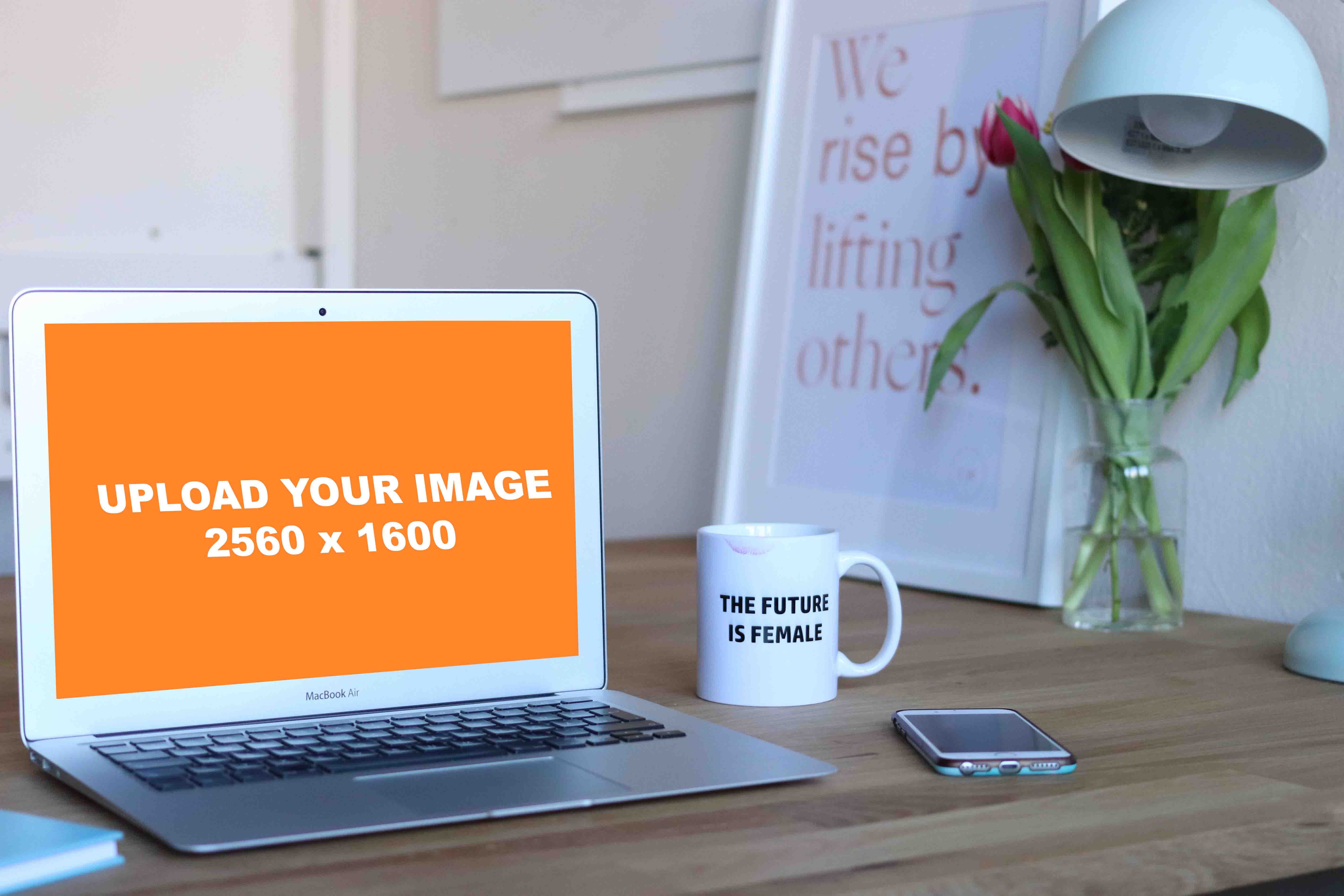 Mockup of Macbook Air beside mug and phone