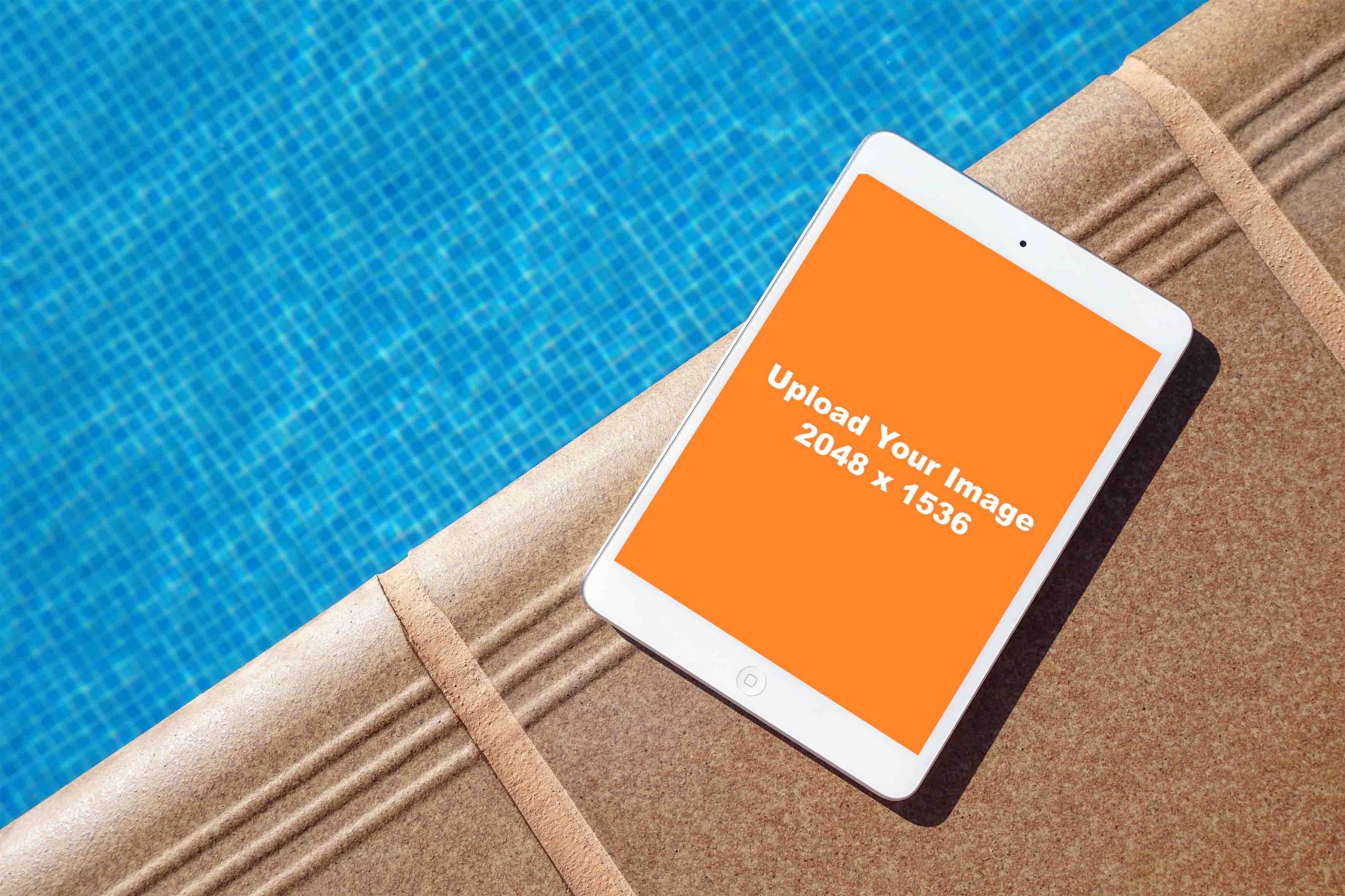 white iPad mockup beside swimming pool